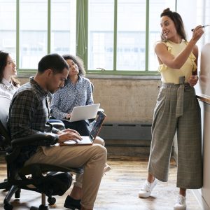 Woman using whiteboard in a small team meeting